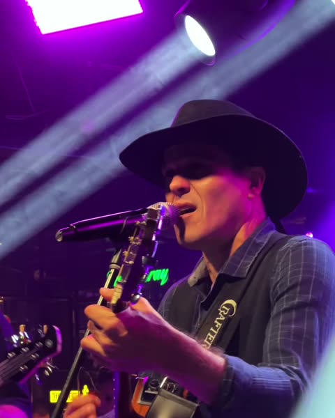 Vocalista caracterizado no bloco country, de chapéu e violão